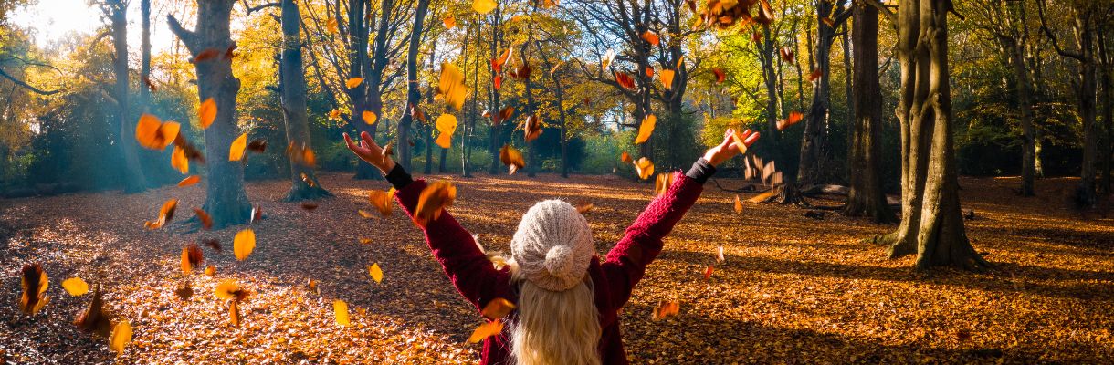 Girl throwing leaves in air during Autumn on the Isle of Wight